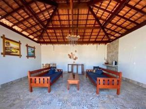 un grand salon avec des canapés bleus et une table dans l'établissement Casa Viva Milagres, PX ao Réveillon dos Milagres, à São Miguel dos Milagres