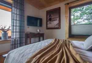Un dormitorio con una cama grande y una ventana en Stacja Murzasichle, en Murzasichle