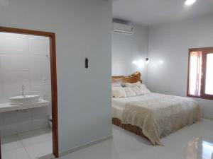 Habitación blanca con cama y lavabo en Casa Viva Milagres, PX ao Réveillon dos Milagres, en São Miguel dos Milagres