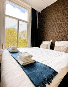een bed met handdoeken en een raam bij Hotel Amsterdam Inn in Amsterdam