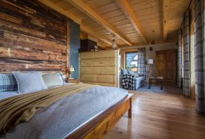 sypialnia z łóżkiem i drewnianą ścianą w obiekcie Stacja Murzasichle w Murzasichlu