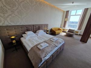 een slaapkamer met een groot bed en 2 handdoeken bij Medos Hotel in Boedapest