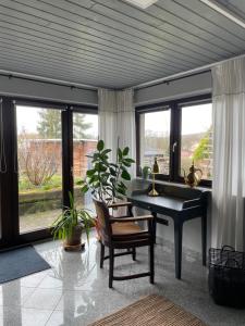 a living room with a desk and chairs and windows at FeWo Eilers in Schönau-Berzdorf