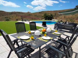 a table with chairs sitting on a patio at Prestige for Home - Moradia Vista Mar, Piscina, Jardim e Estacionamento in Nora