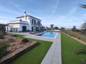 a house with a swimming pool in front of a yard at Prestige for Home - Moradia Vista Mar, Piscina, Jardim e Estacionamento in Nora