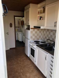 uma cozinha com um fogão e um lavatório em Föllingen stugan em Kisa