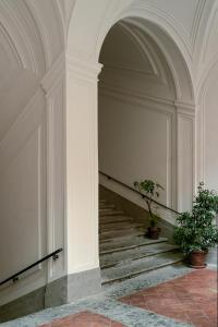 an archway with a staircase in a building with potted plants at Carafa di Maddaloni By Enjoy Napoli in Naples