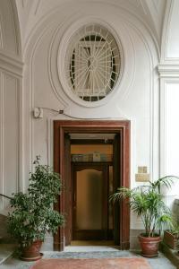 a door in a building with two potted plants at Carafa di Maddaloni By Enjoy Napoli in Naples