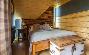 a bedroom with a bed and a wooden wall at Stacja Murzasichle in Murzasichle