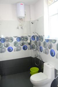 a bathroom with a toilet and a blue and white wall at Vanam Holidays Inn in Ooty