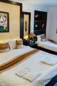 Habitación de hotel con 2 camas y toallas. en Pai Residence Hotel, en Chiang Mai