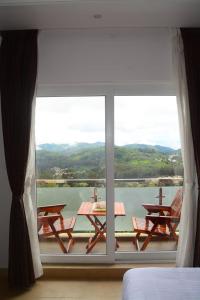 a bedroom with a large window with a view of the water at Vanam Holidays Inn in Ooty