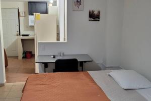 Un dormitorio con una cama y un escritorio y una cocina. en Loft Centrico 4 camas ,Aire acondicionado,WIFI, parking, refrigerador, microhondas, en Ciudad Valles