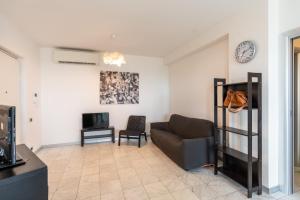 ein Wohnzimmer mit einem Sofa und einem TV in der Unterkunft Beachfront Luxurious Newly Built 2-Bed Flat with Stunning Sea Views & Terrace in Roseto degli Abruzzi