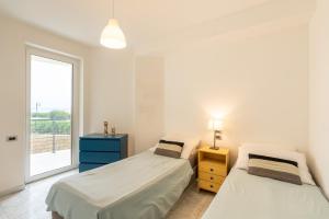 Duas camas num quarto com uma janela em Beachfront Luxurious Newly Built 2-Bed Flat with Stunning Sea Views & Terrace em Roseto degli Abruzzi