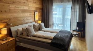 1 dormitorio con 1 cama con pared de madera en Exklusive Familienappartments Zugspitze, en Garmisch-Partenkirchen
