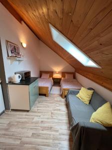 a room with two beds and a kitchen with a skylight at Apartments and Rooms Kristina in Drežnik Grad