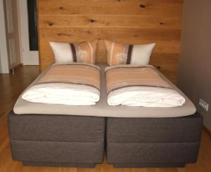 a bed with a head board and pillows on it at Exklusive Familienappartments Zugspitze in Garmisch-Partenkirchen