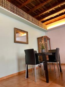 a dining room table with black chairs and a mirror at Laterano Apartment in Rome