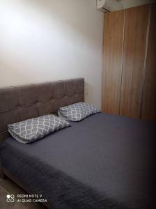 1 cama con 2 almohadas en una habitación en Maison de village vue mer, en Skhinokápsala
