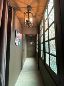 an empty hallway with a chandelier and windows at Une Nuit Comme Un Chevalier! Coeur historique - Hypercentre. in Troyes