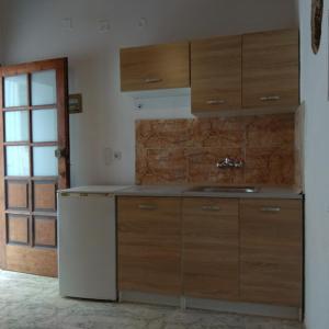 a kitchen with wooden cabinets and a white refrigerator at Kastania..2 in Kiolianá