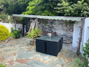 a stone patio with a black table in a yard at Fishermens cottage with secret garden in Port Isaac