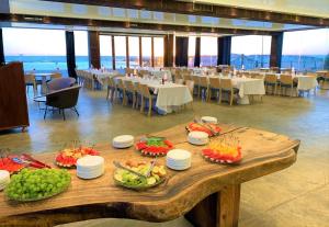 a table with plates of fruit on it in a restaurant at Nachsholim Kibbutz Country Lodging in Nachsholim