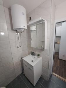 a white bathroom with a sink and a mirror at Daka in Vrnjačka Banja +5 photos