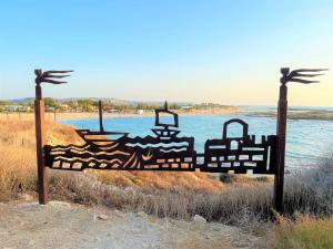 a wooden bed in front of a body of water at Nachsholim Kibbutz Country Lodging in Nachsholim