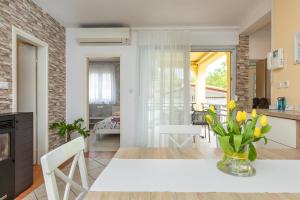 cocina y sala de estar con mesa blanca y sillas en Apartment Blazi Njivice, en Njivice