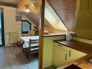 eine Küche und ein Esszimmer mit einem Tisch in einem winzigen Haus in der Unterkunft Apartment Cvetek Janez in Bohinj