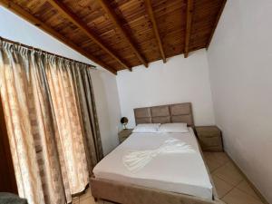 a bedroom with a bed with a wooden ceiling at Alex Apartments in Sarandë
