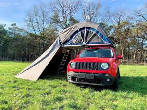 a red jeep with a tent on top of it at Shackleton Rooftop Tent Rental from ElectricExplorers in Hawkshead