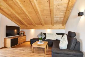 ein Wohnzimmer mit einem Sofa und einem TV in der Unterkunft Krennlehen in Schönau am Königssee