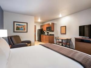 My Place Hotel-Grand Forks, ND في غراند فوركس: غرفة فندقية بسرير وتلفزيون بشاشة مسطحة