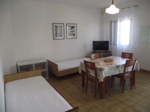 ein kleines Zimmer mit einem Tisch und einem Bett sowie einem Tisch und Stühlen. in der Unterkunft Apartments Milo in Kukljica