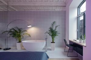 a bathroom with a white tub and two potted plants at Major's House Gyumri in Gyumri