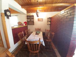 d'une salle à manger avec une table, des chaises et un mur en briques. dans l'établissement Vikendica odmor za dusu, à Visoko