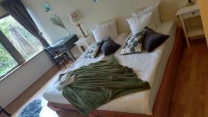 a bed with a green blanket on it in a room at Møn Klintholm Vintage B&B in Borre