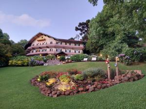 um grande edifício com um jardim de flores em frente em Hotel das Hortênsias em Gramado