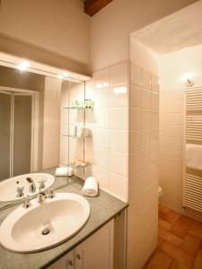 a bathroom with a sink and a mirror at Cora Aparthotel Stradivari in CastellʼArquato