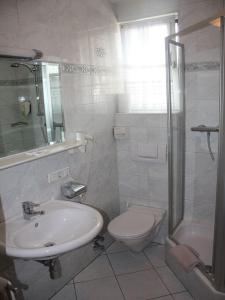 a white bathroom with a sink and a toilet at Gasthof Post in Frankenmarkt