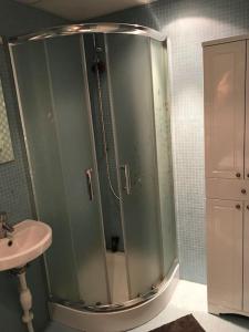 La salle de bains est pourvue d'une douche en verre et d'un lavabo. dans l'établissement Loft Tartu kesklinnas, à Tartu