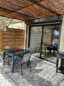 a patio with a table and chairs and a grill at Famaméro in Sanary-sur-Mer