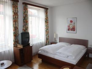 1 dormitorio con 1 cama y TV. en Gasthof Post en Frankenmarkt