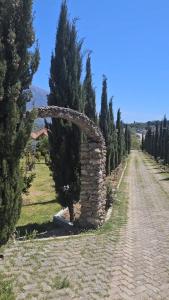 a stone archway on a dirt road with trees at Guesthouse Lord Byron in Tepelenë
