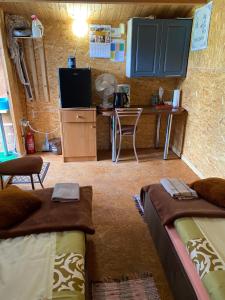 a room with two beds and a desk and a tv at POKOJE GOŚCINNE RENATA KNITTER in Komnino