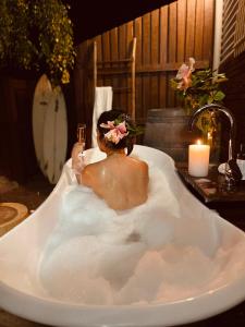 a man sitting in a bath tub with a glass of wine at Grape Juice Retreat in Margaret River Town