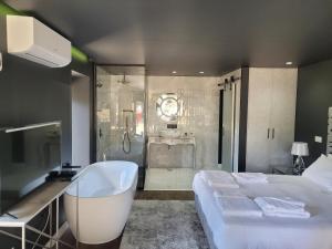 bagno con letto, vasca e doccia di INFINITY HOUSES a Ponte da Barca